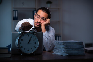 Young male employee working in the office night time