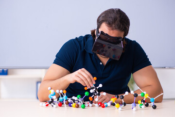 Young male scientist sitting in the classroom