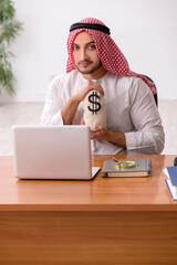 Young male arab employee working in the office