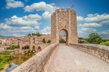 Fototapeta na wymiar Medieval gated bridge with tower in Besalu Catalonia Spain with cloudy blue sky