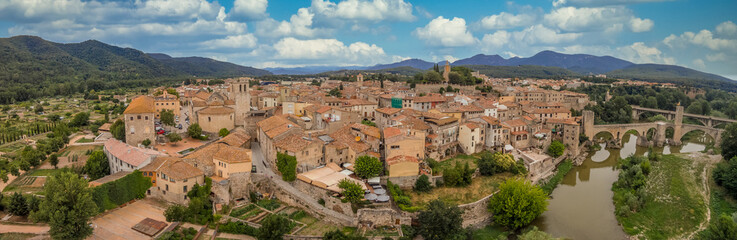 Fototapeta na wymiar Aerial panorama view of medieval Besalu, home to the older synagogue in Catalonia Spain with cloudy blue sky