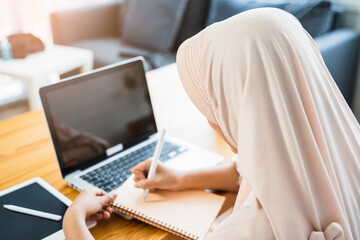 New normal close up Muslim woman working at home business planning innovation ideas researching strategy freelance worker using smart laptop tablet pen device technology, home modern office work space