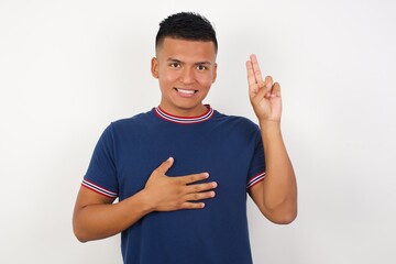 Young handsome hispanic man wearing casual t-shirt standing over white isolated background smiling...