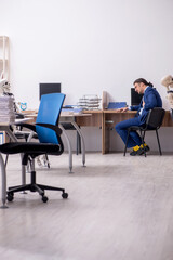 Young male employee with skeletons in the office