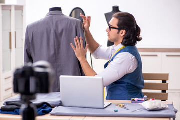Young male tailor recording video for his blog