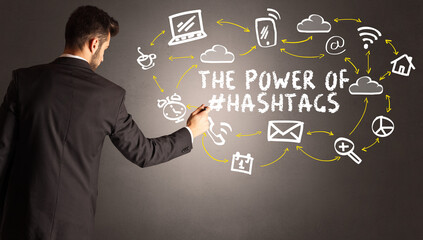 businessman drawing social media icons with THE POWER OF #HASHTAGS inscription, new media concept