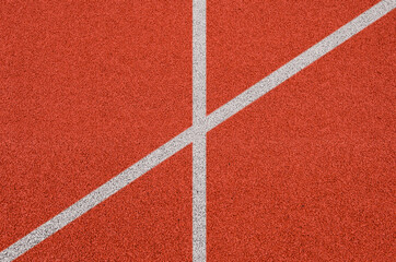 Fototapeta premium Top view of the running track rubber lanes cover texture with white line marking for background.