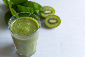 healthy fresh natural green smoothie in glass. Made from spinach and kiwi. Detox day. Grey background 