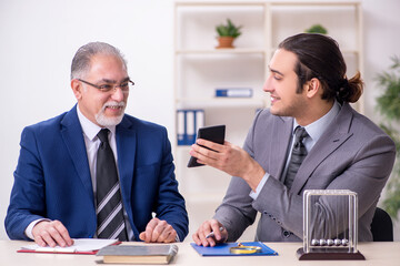 Two businessmen and meditation balls on the table