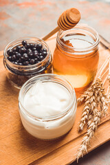 Ingredients for making tasty and healthy dessert with greek yogurt, berries and honey. Selective focus.