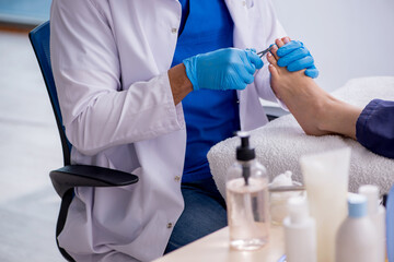 Podiatrist treating feet during procedure