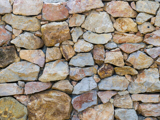 A wall of rough stones. Natural texture. Yellow-brown stones