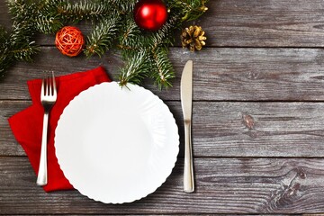 christmas table setting.Christmas cutlery with a plate and a red napkin on a wooden background. New year and christmas concept.