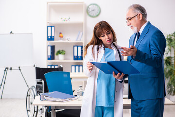 Obraz premium Old businessman visiting young female doctor