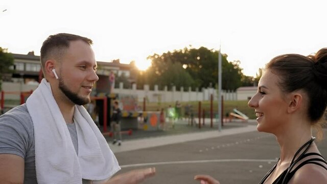 Close-up of a sporty couple clapping their hands at a stadium after a workout or jog.