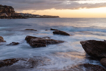 Sea water flow between rocks on the coastline.