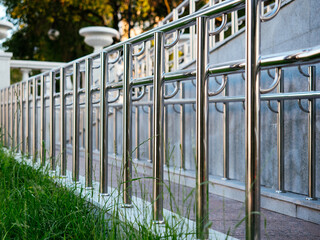 Chrome-plated metal railing in the Park. Ramp for disabled people and wheelchairs. Background with...