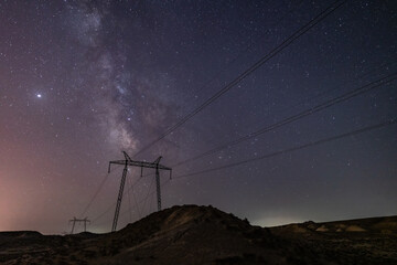 Milky Way galaxy in the night sky above power line supports