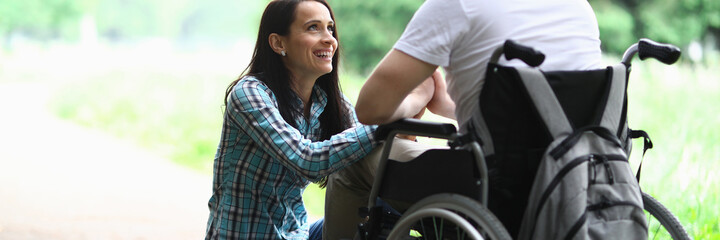 Disabled couple in love on a walk in park portrait. Wife looks at her husband in love with eyes....
