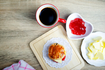 Close up of Red cup coffee drinks with scone and butter jam on wooden table backgrounds above