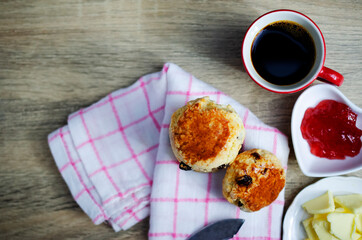 Close up of Scone homemade raisin  adn red cup coffee on wooden table backgrounds above
