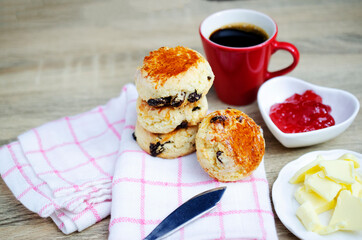 Close up of Scone homemade raisin  adn red cup coffee on wooden table backgrounds