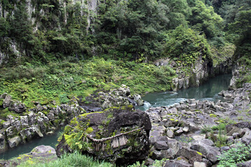Fototapeta na wymiar Rock, shimenawa rope, and river around Takachiho Gorge
