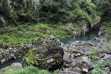 Rock, shimenawa rope, and river around Takachiho Gorge