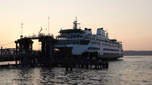 Mukilteo ferry leaves dock to cross Puget Sound in Washington state at sunset