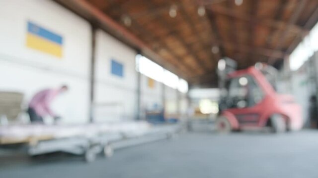 Forklift driver loads Rolls of steel sheet. Industrial warehouse with rolls of steel sheet. Blurred