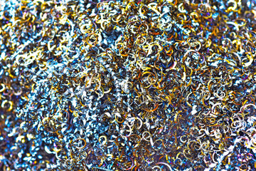 光る大量のカラフルな金属スクラップ