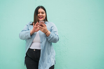 Young plus size woman using her mobile phone.