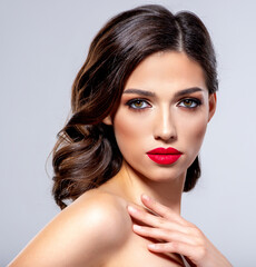 Beautiful young fashion woman with red lipstick.  Brunette woman with a clean skin of face. Portrait of model with bright red lips. Glamour fashion model with bright gloss make-up  posing at studio.