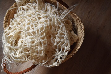 ivory crochet shawl in a basket. knitting fabric.