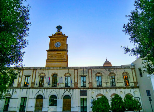 Street view in Bernalda at sundown with City Hall and Clock Tower, Matera district, Basilicata, Italy.