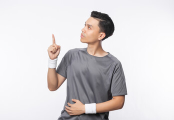 Young handsome asian sport man pointing to copy space isolated on white background.