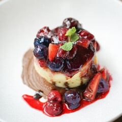 Pancake. Top view of a berries pancakes (blueberries and raspberries) topping with strawberry sauce and mint leaf.