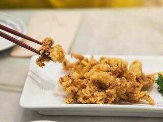 Chopsticks is holding crispy squids fries on desk