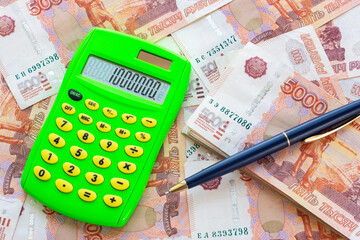 The number 1,000,000 is written on the calculator, the calculator and the ballpoint pen lie on a pile of money