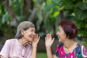 Daughter talking to hearing impaired elderly woman