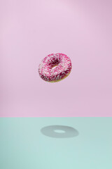 Donuts flying over a blue and pink background. Minimal bakery, baking concept. Levitation.