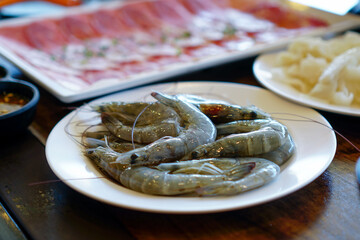 Fresh raw shrimps set with vegatables on the bamboo basket ready for cooking