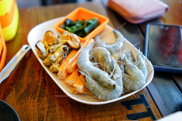 Fresh raw shrimps set with vegatables on the bamboo basket ready for cooking
