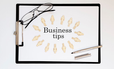Business Tips text on sheet with wooden peopl