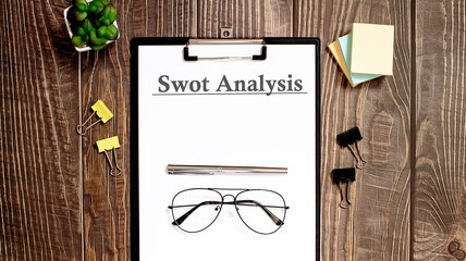 swot analysis form on a wooden table.