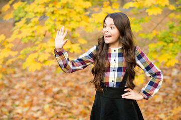 kid in autumn park. cheerful girl with yellow maple leaves. happy kid enjoy fall weather. small...