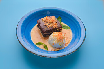 Traditional brownie cake with cold ice ice cream. Delicious chocolate cacao dessert with vanilla caramel ice cream.