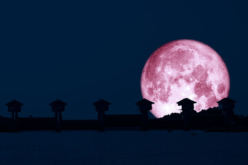 Super pink moon and silhouette dam in the night sky