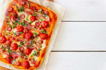 Pizza with bacon, sausage, mozzarella, tomatoes and basil. Italian cuisine. Recipe.