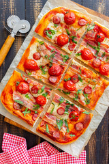 Pizza with bacon, sausage, mozzarella, tomatoes and basil. Italian cuisine. Recipe.